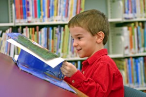 boy reading book at the library
